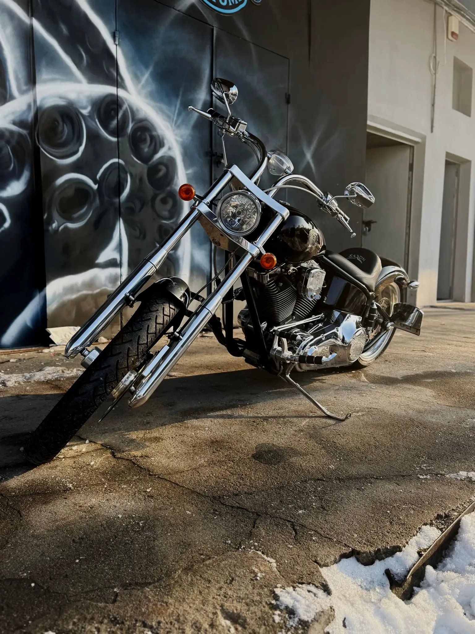Chopper z długim przednim widelcem przed muralem Heavyweight Garage w Gdyni