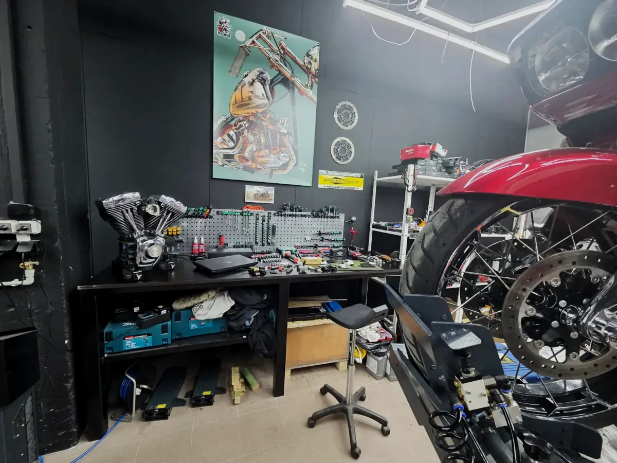 Mechanik Heavyweight Garage przy silniku Harley-Davidson Road King na podnośniku