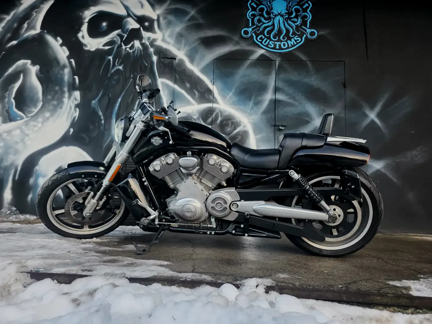 Harley-Davidson V-Rod Muscle z boku przed muralem Heavyweight Garage w Gdyni