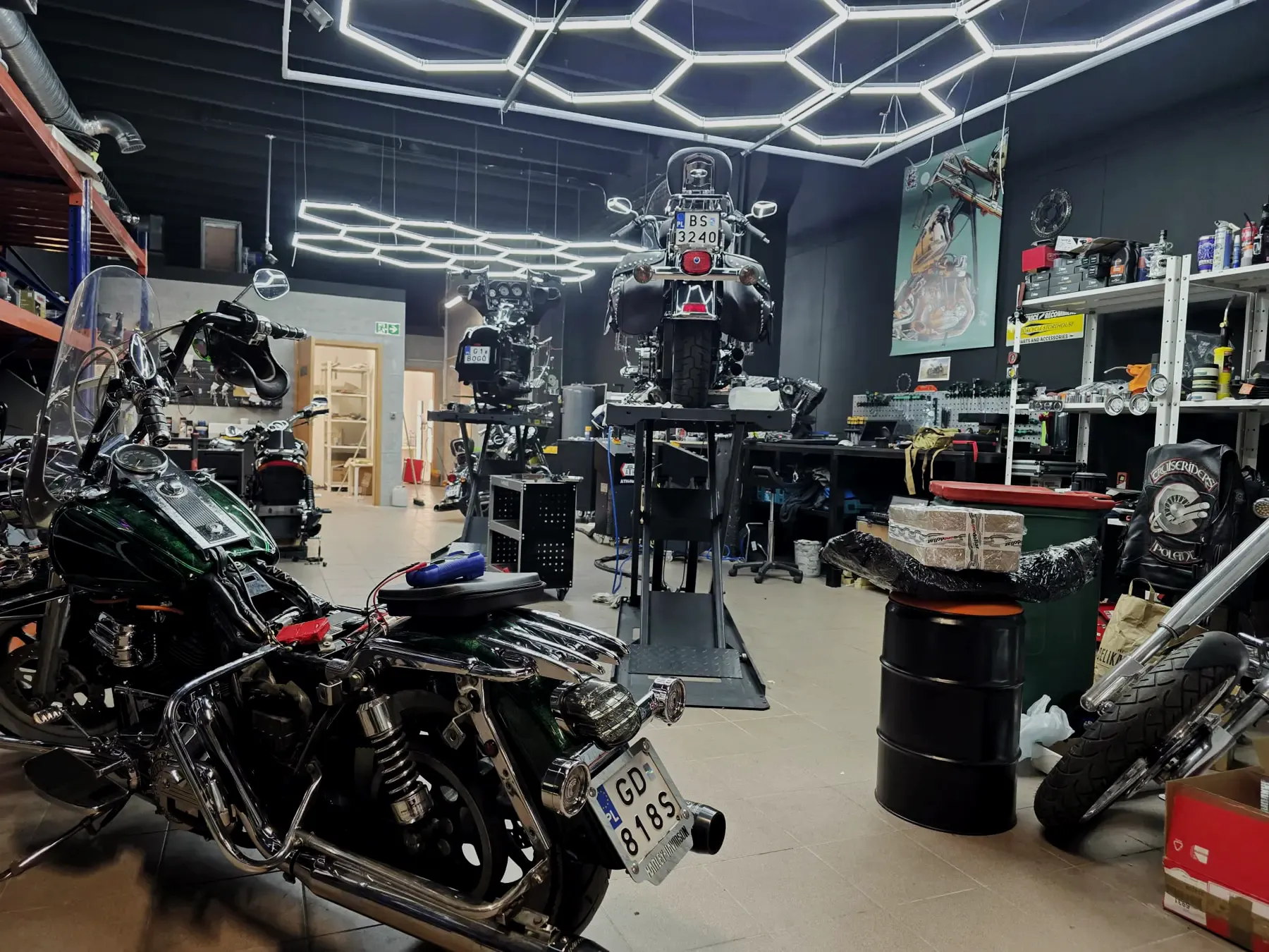 Wnętrze warsztatu Heavyweight Garage w Gdyni z sześciokątnym oświetleniem i motocyklami Harley-Davidson na podnośnikach
